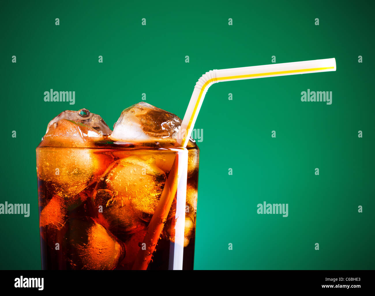 glass of cola with ice and straw on green background Stock Photo - Alamy