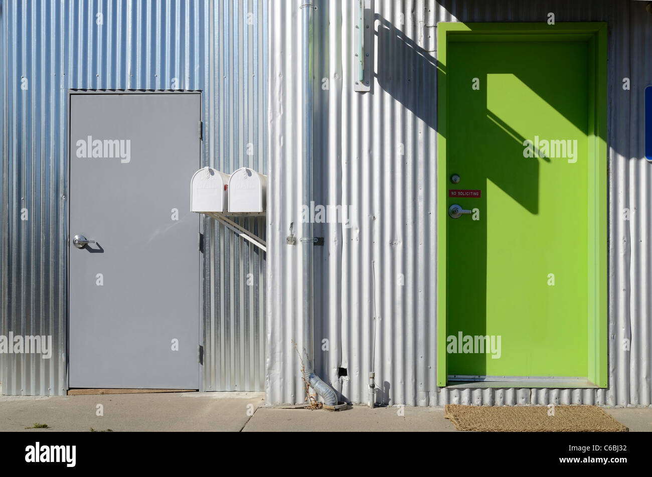 Grey door and green door on an industrial estate Stock Photo