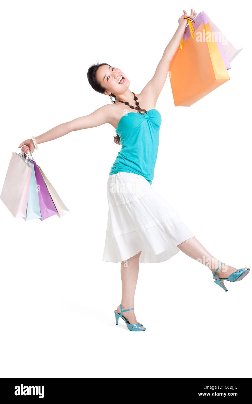 Studio shot of a young woman carrying shopping bags Stock Photo - Alamy