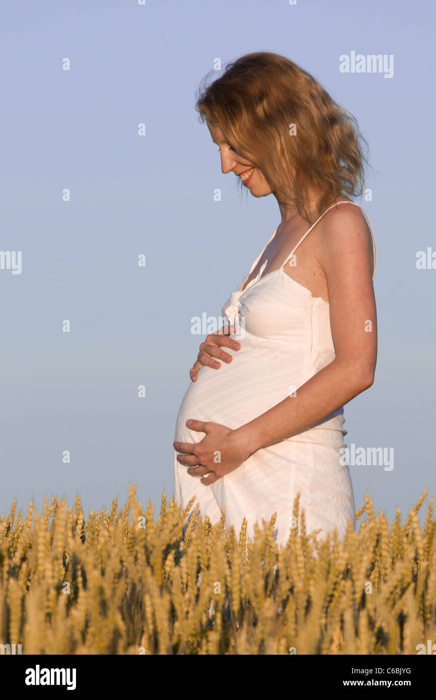 pregnant woman in white dress relaxing outdoors Stock Photo - Alamy