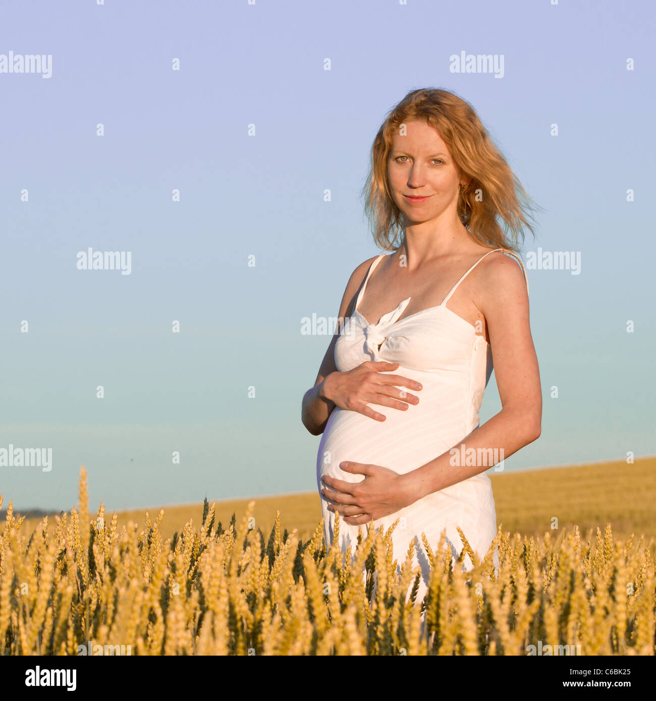 pregnant woman in white dress relaxing outdoors Stock Photo - Alamy