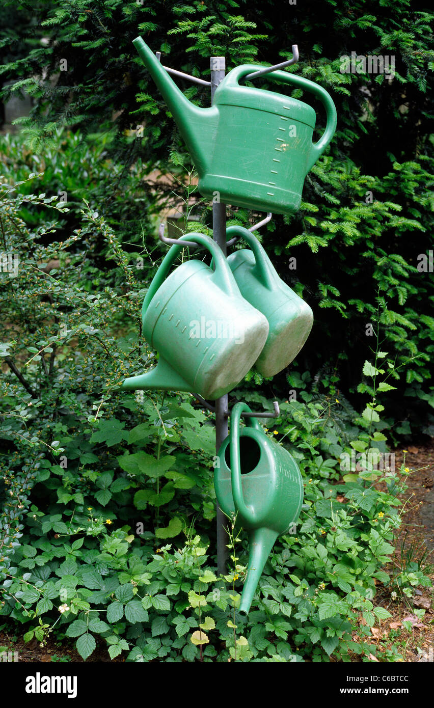 Plastic watering cans on a pole at Zentralfriedhof (central cemetery) in Frankfurt am Main. Stock Photo