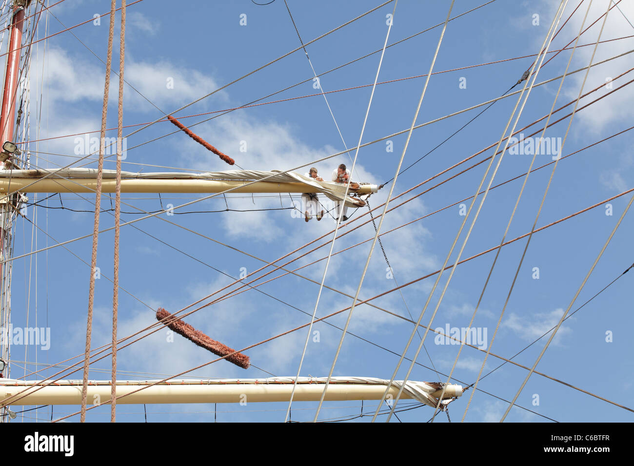 Tall Ships Race, crew members working on the sails and rigging of a