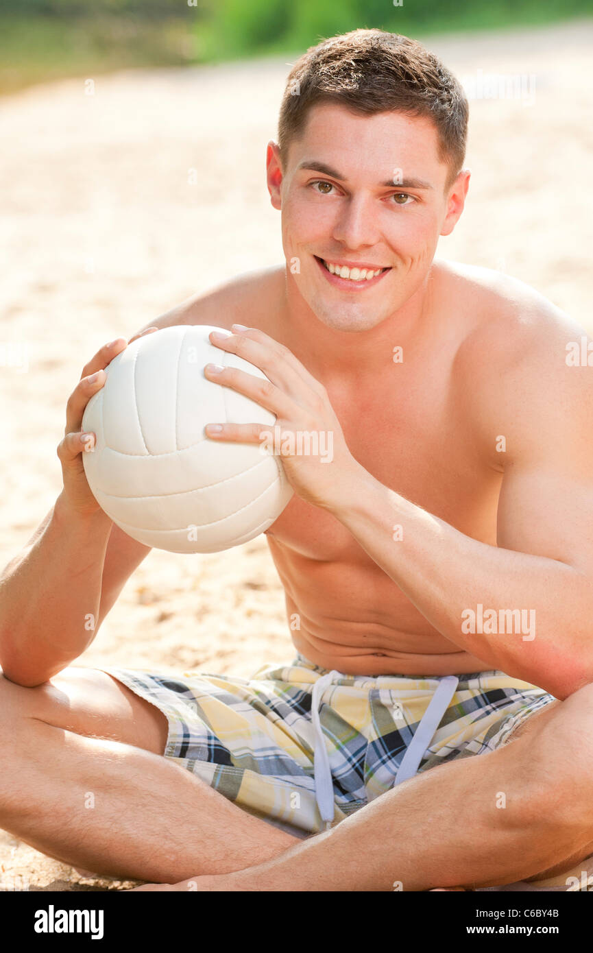 Young and smiling man with ball at the beach Stock Photo Alamy