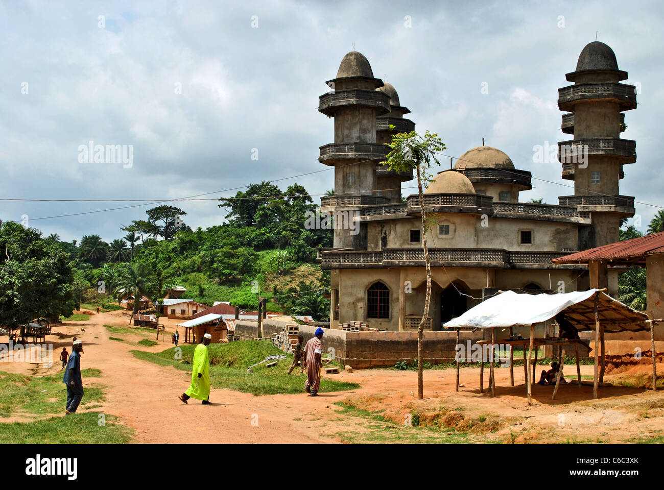 Muslims cross a road to go to the mosque in a small village between Kolahun and Bolahun, Liberia, West Africa Stock Photo