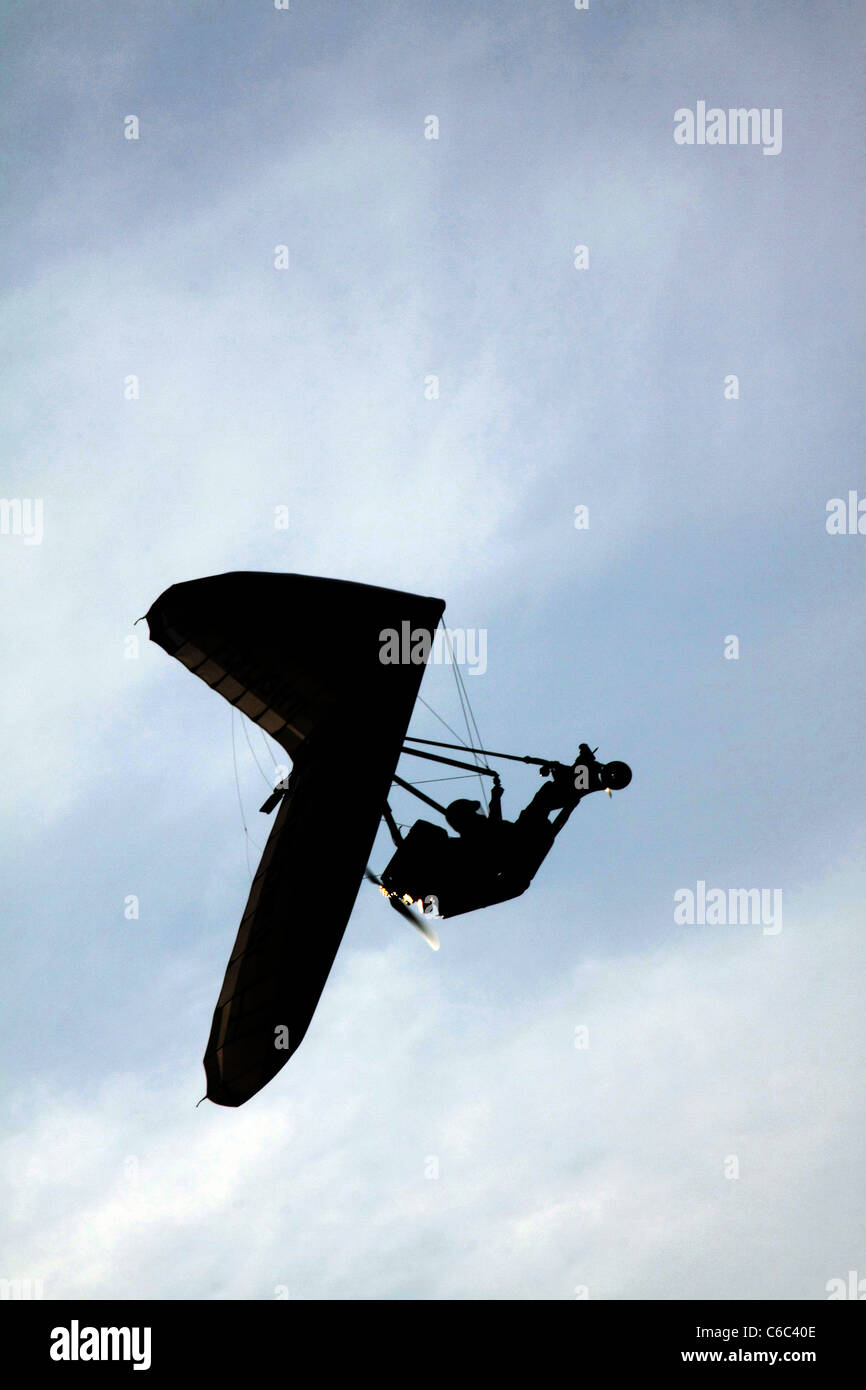 Flexwing microlight flying against blue sky and clouds Stock Photo
