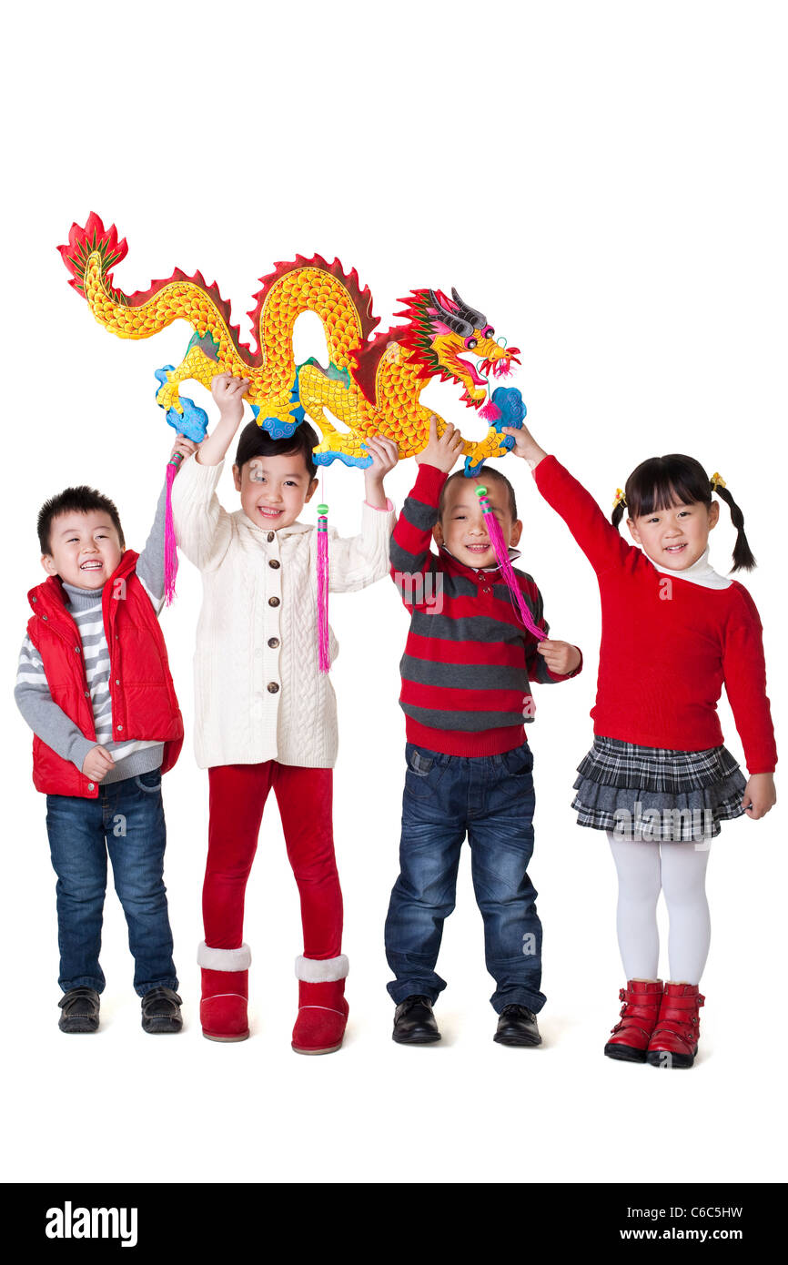 Four Chinese children holding Chinese dragon aloft Stock Photo