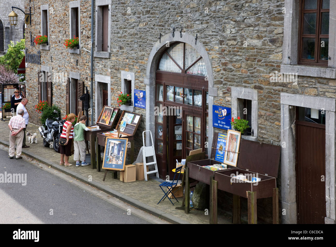 Tourists choosing books from bookshop in the book town Redu, Belgian Ardennes, Luxembourg, Belgium Stock Photo