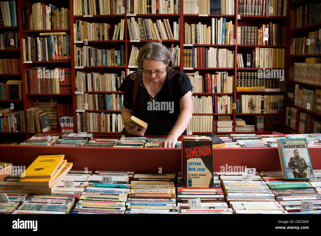Woman looking for books in bookshop at the book town Redu, Belgian Ardennes, Luxembourg, Belgium Stock Photo
