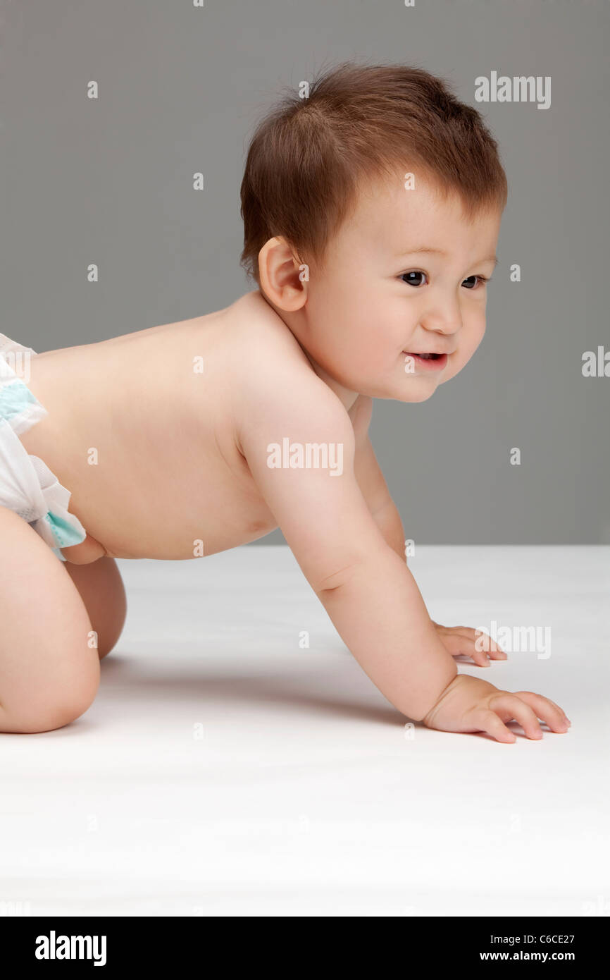 Studio shot of a cute baby boy crawling Stock Photo