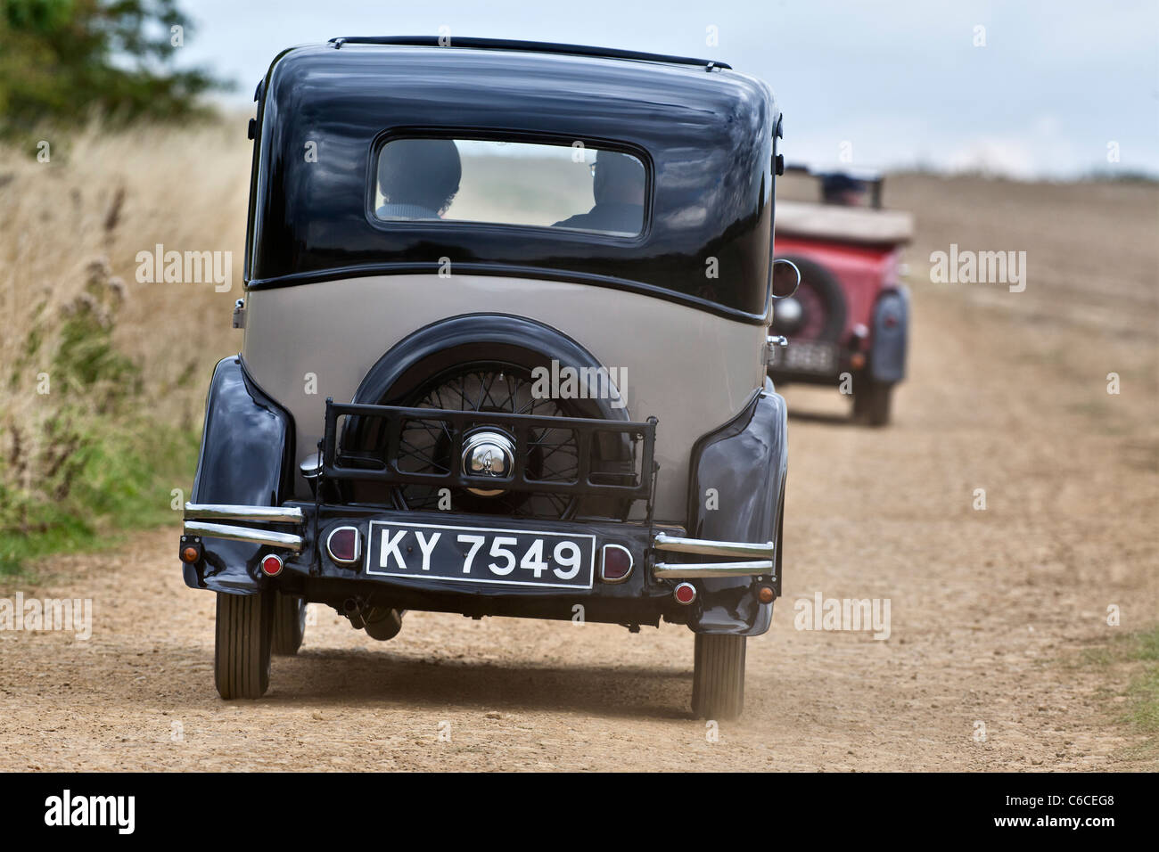 Vintage Austin 7 saloon travelling along a dusty road Stock Photo