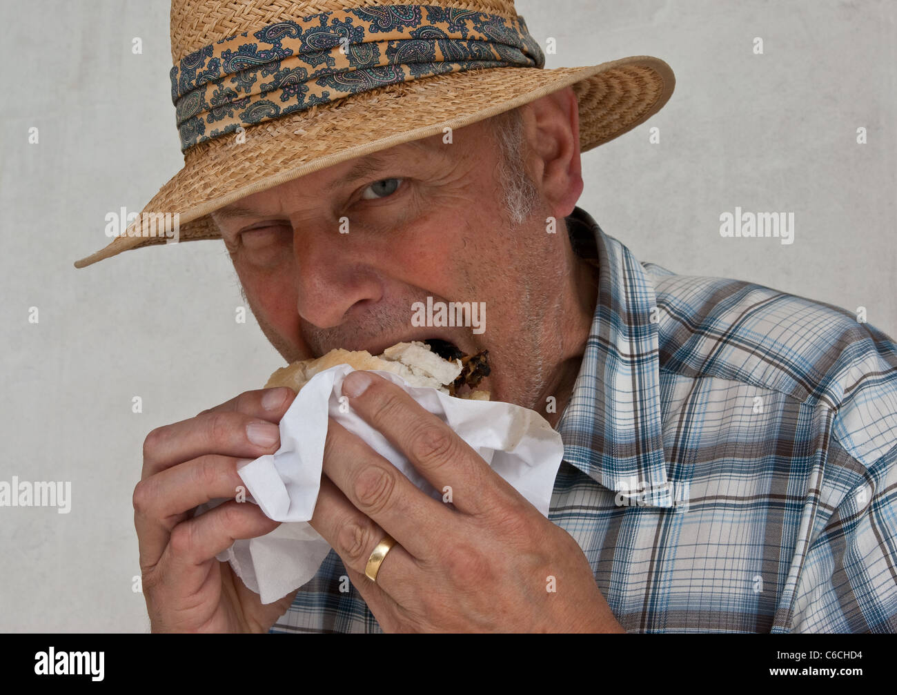 Head and shoulders shot of a middle aged man eating junk food. Stock Photo