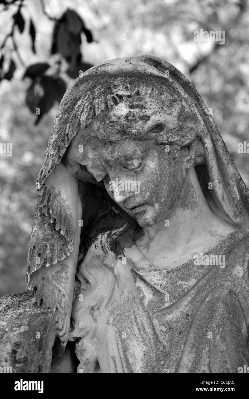 A black and white close up view of a stone angel memorial in a old cemetary Stock Photo