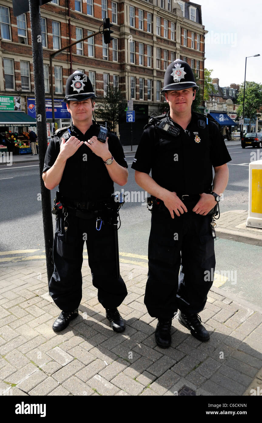 Two Welsh Heddlu or police officers, dressed in riot gear on the streets of London England UK Stock Photo