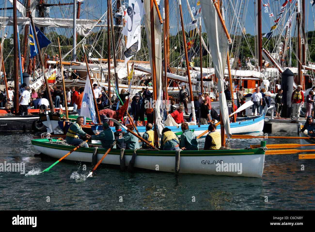 A skiff leaves port, the crew rowed,  Rosmeur port,  gathering  of traditional wooden boats (Douarnenez, France). Stock Photo