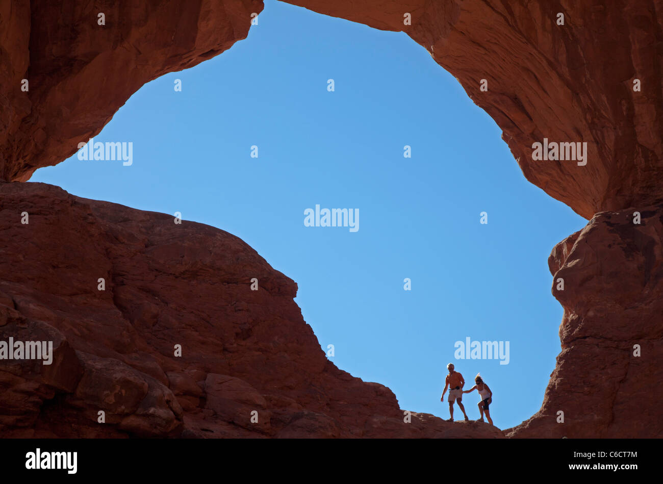 Moab, Utah - A couple in one of the arches at Double Arch in Arches National Park. Stock Photo