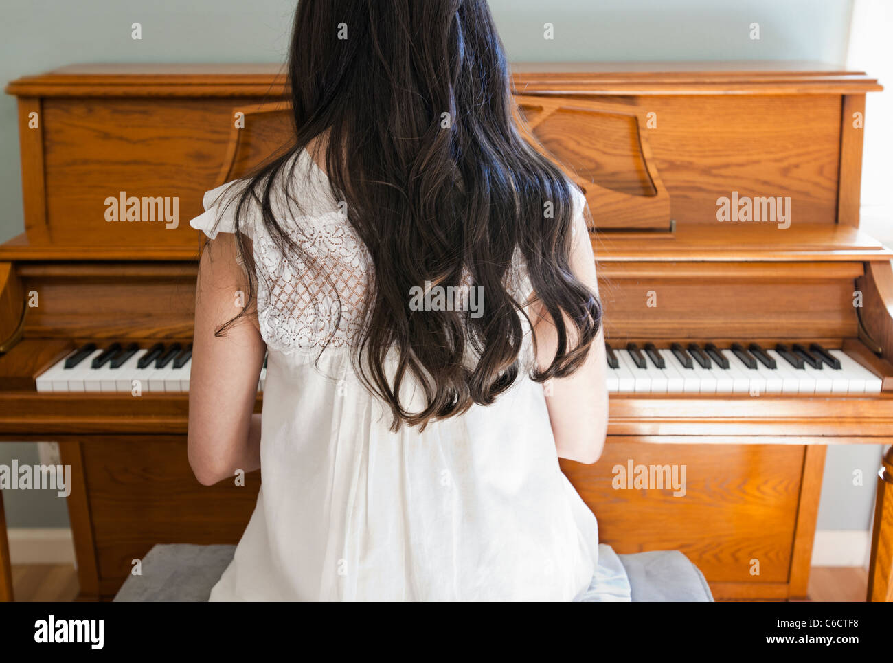 Mixed race woman playing piano Stock Photo