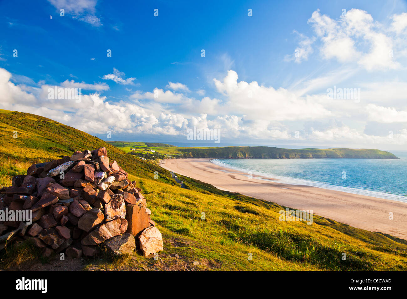 Evening light on the cairn on Potter's Hill overlooking Woolacombe and Putsborough Sands towards Baggy Point, Devon, England, UK Stock Photo