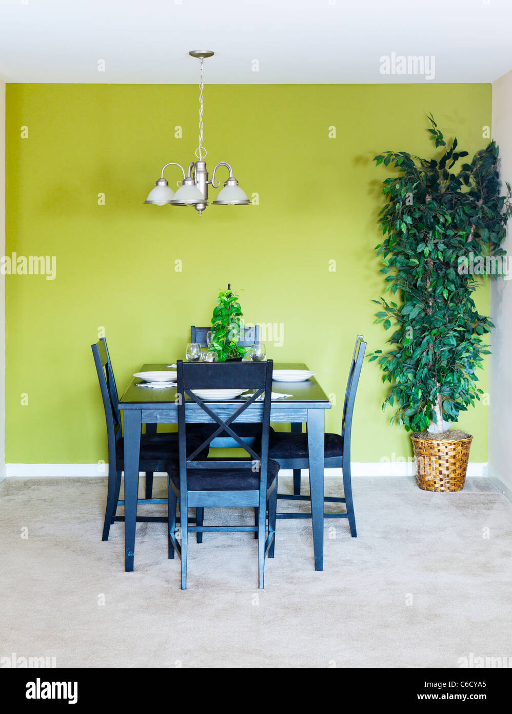 Dining area with black dining set and a tree Stock Photo