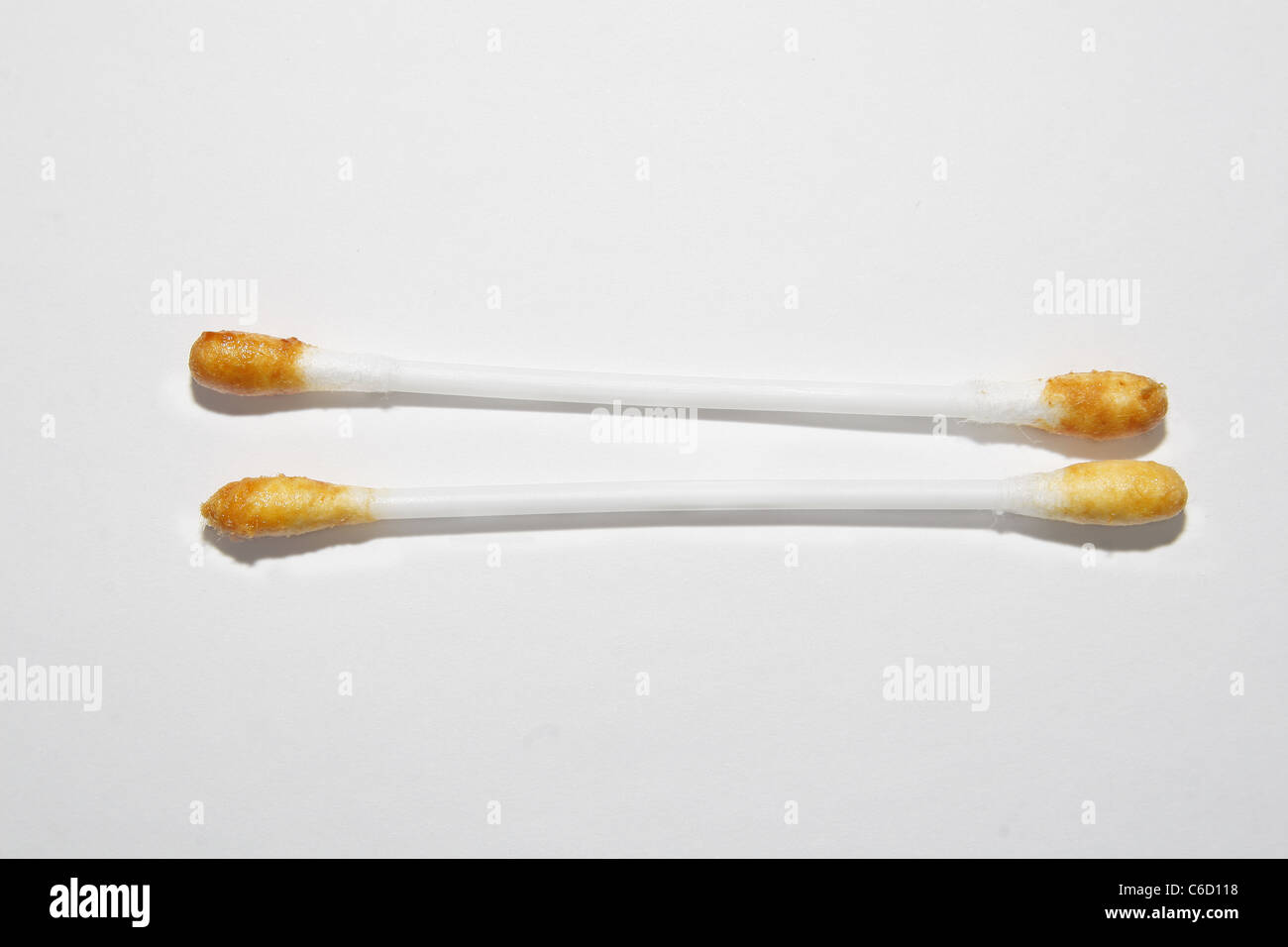 cotton buds covered in ear wax on white background Stock Photo