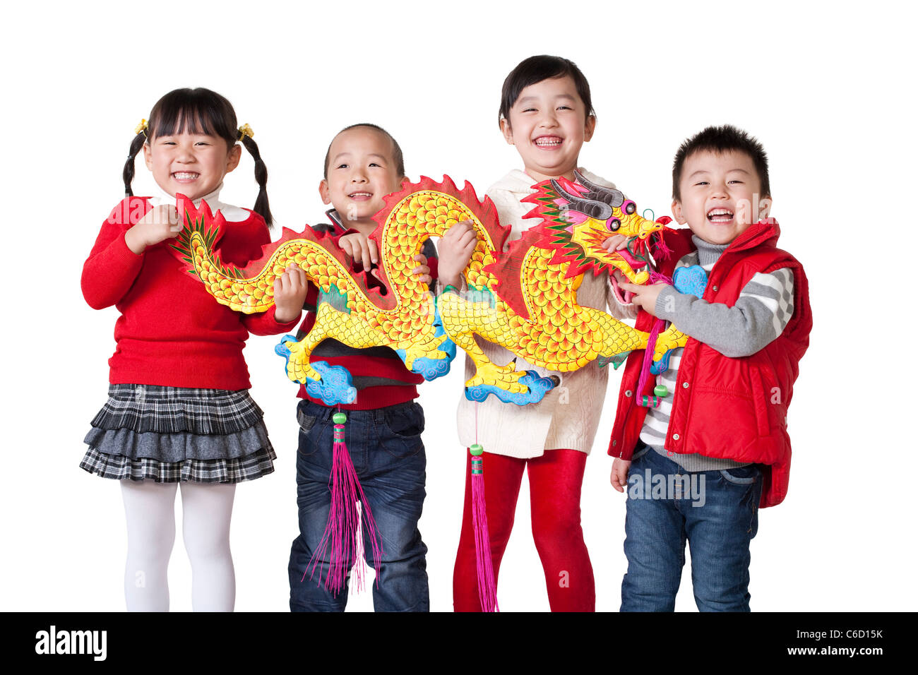 Four Chinese children holding Chinese dragon aloft Stock Photo