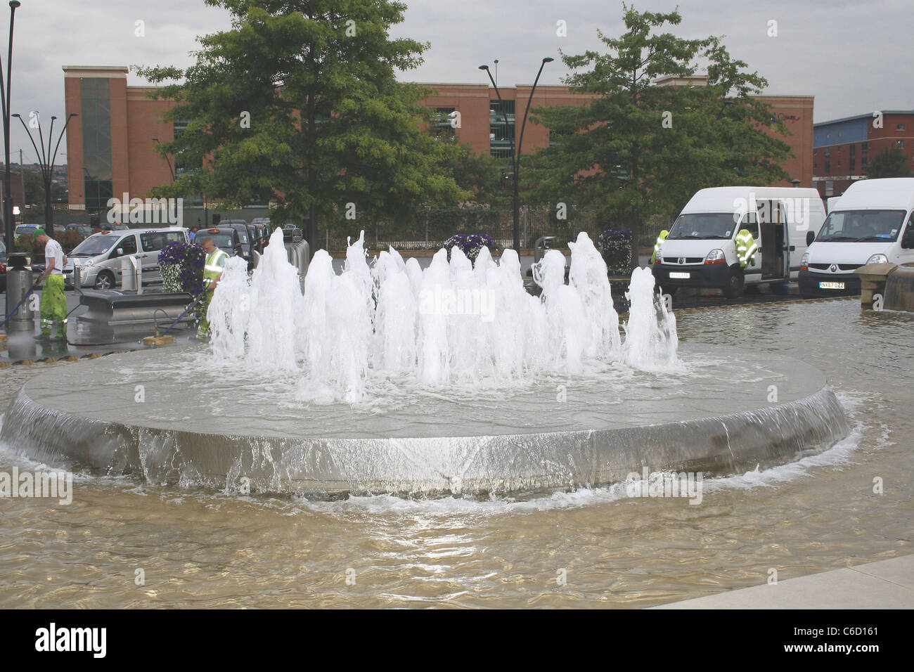 water feature outside sheffield train station, with men cleaning pavement in background. Sheffield, South Yorkshire, England Stock Photo