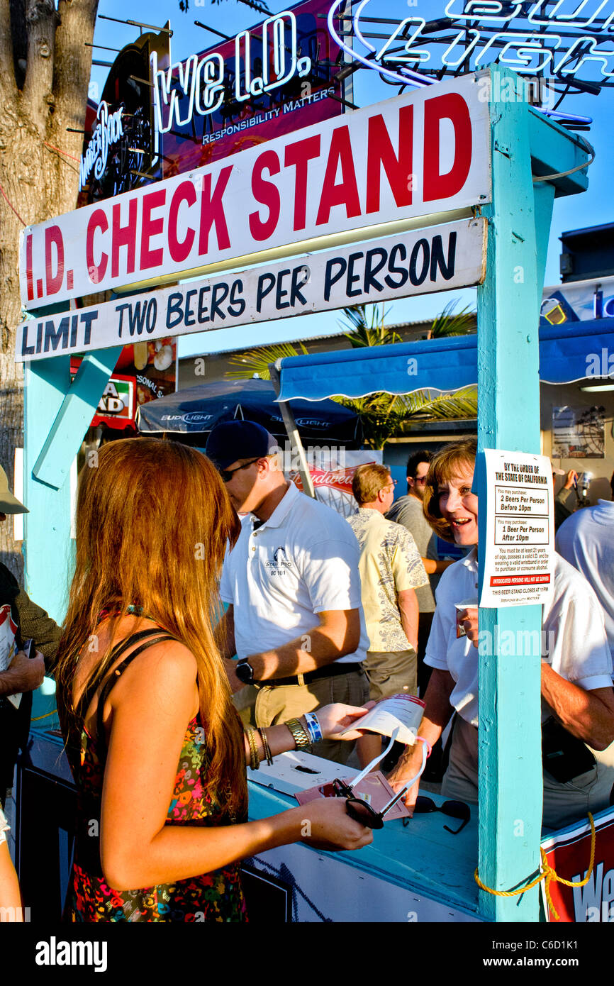 Beer drinkers have their age identity checked by a drinks concession at