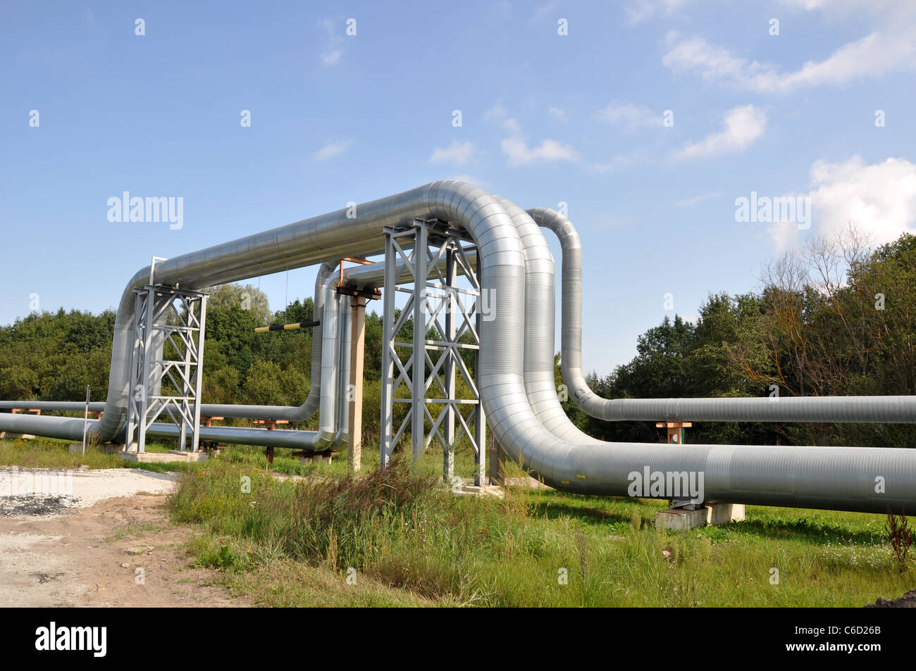 Industrial pipelines on pipe-bridge against blue sky Stock Photo - Alamy