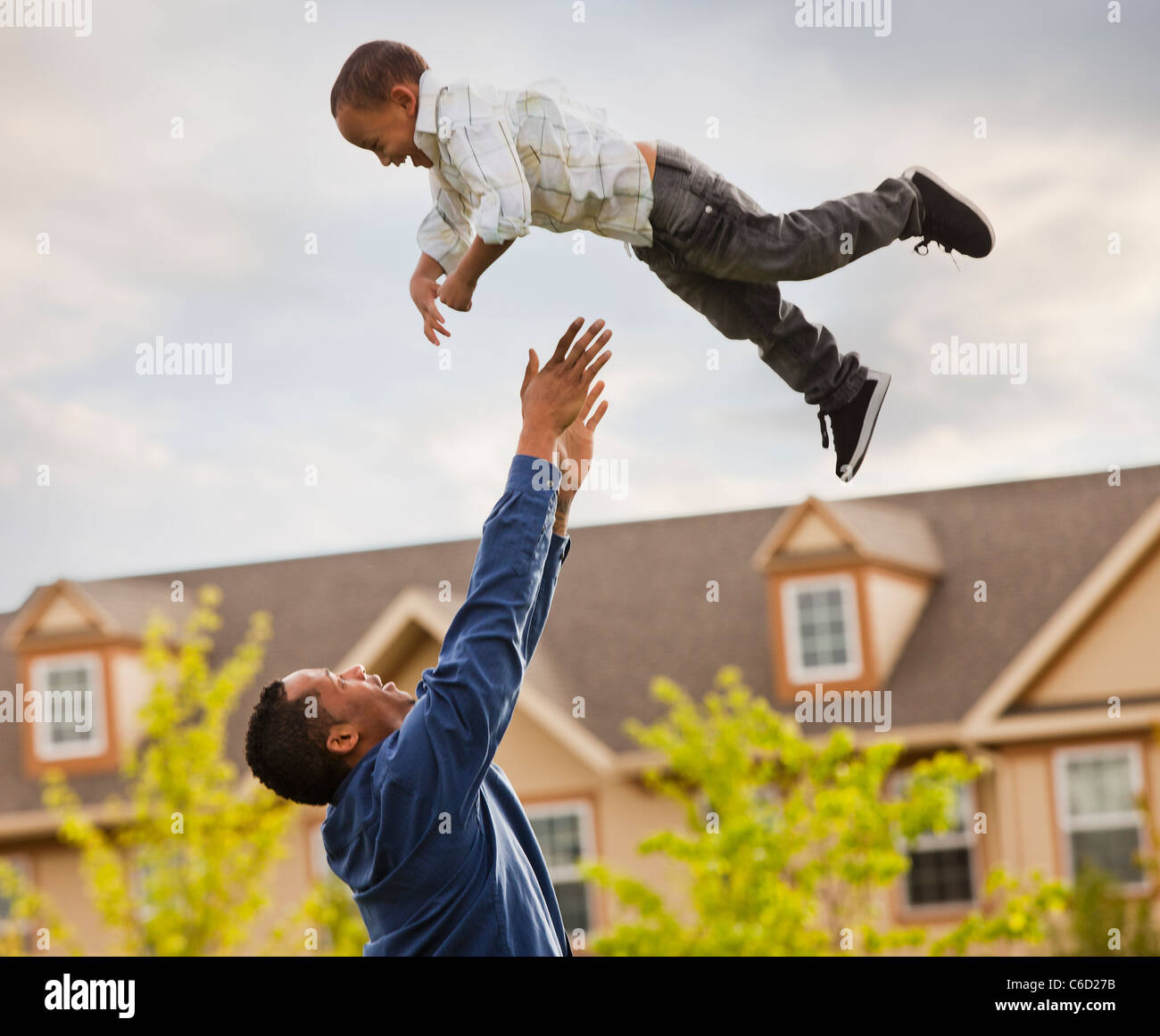 Father throwing son into the air Stock Photo Alamy