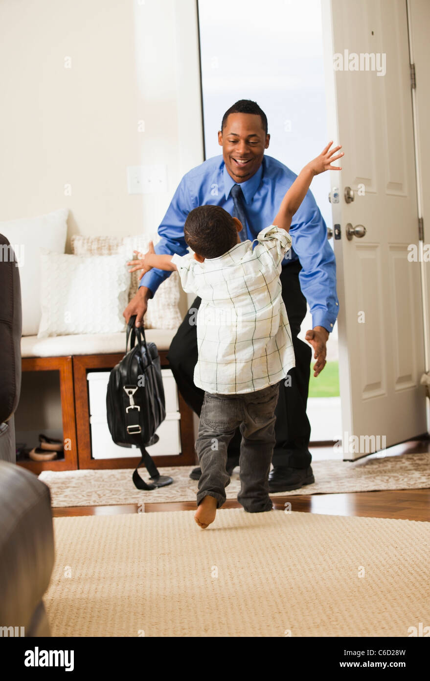 Greeted Businessman returning from work being greeted by son Stock Photo - Alamy