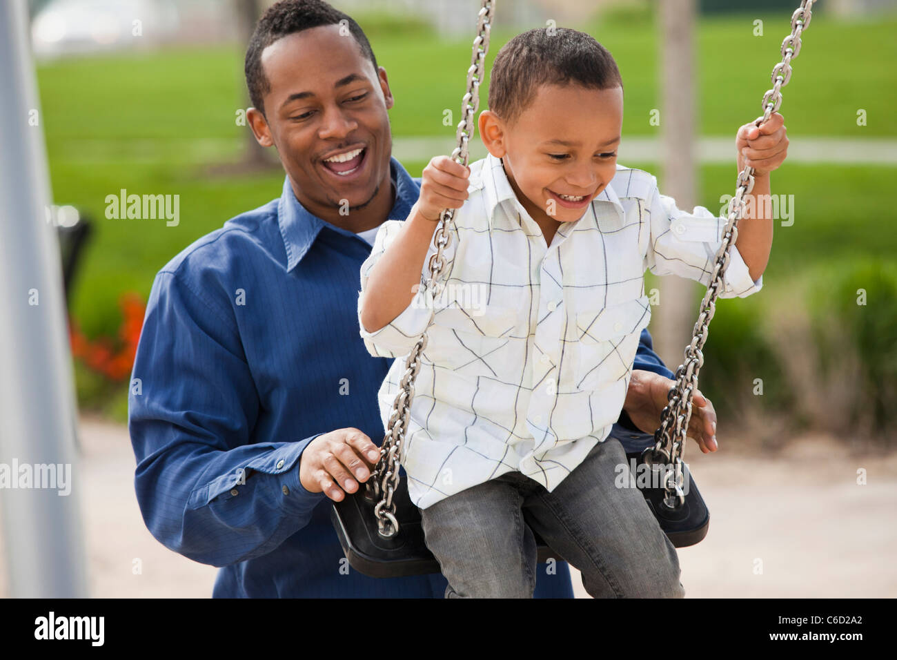 Father Pushing Son On Swing Stock Photo Alamy