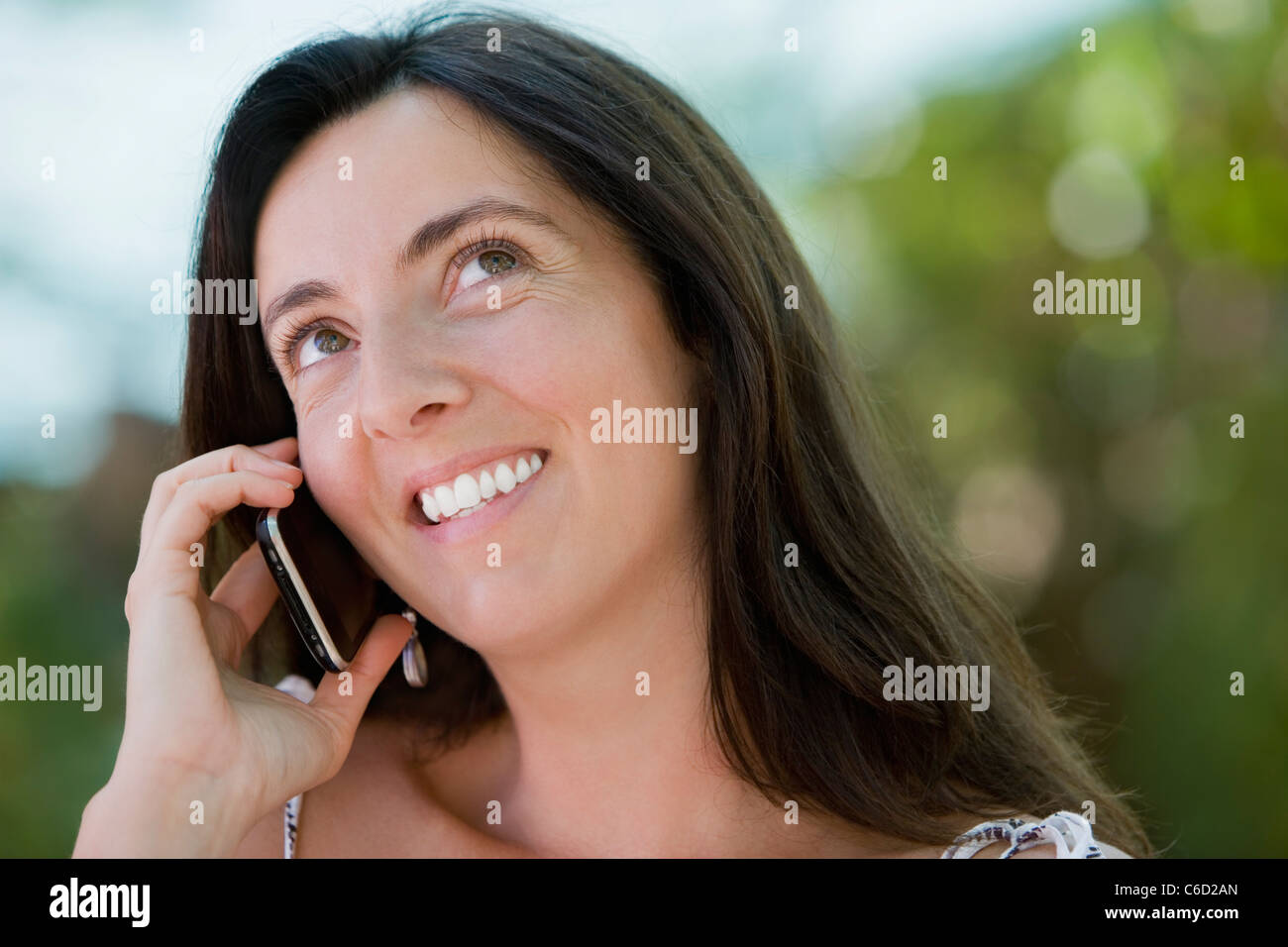 Hispanic woman talking on cell phone Stock Photo - Alamy