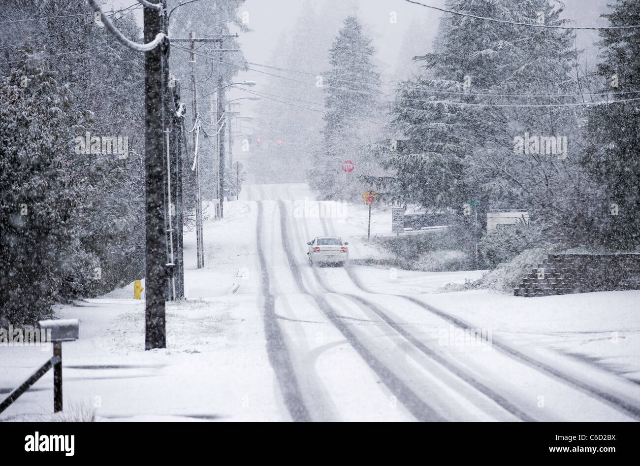 Car driving on residential street during snowstorm, Seattle, Washington, USA Stock Photo