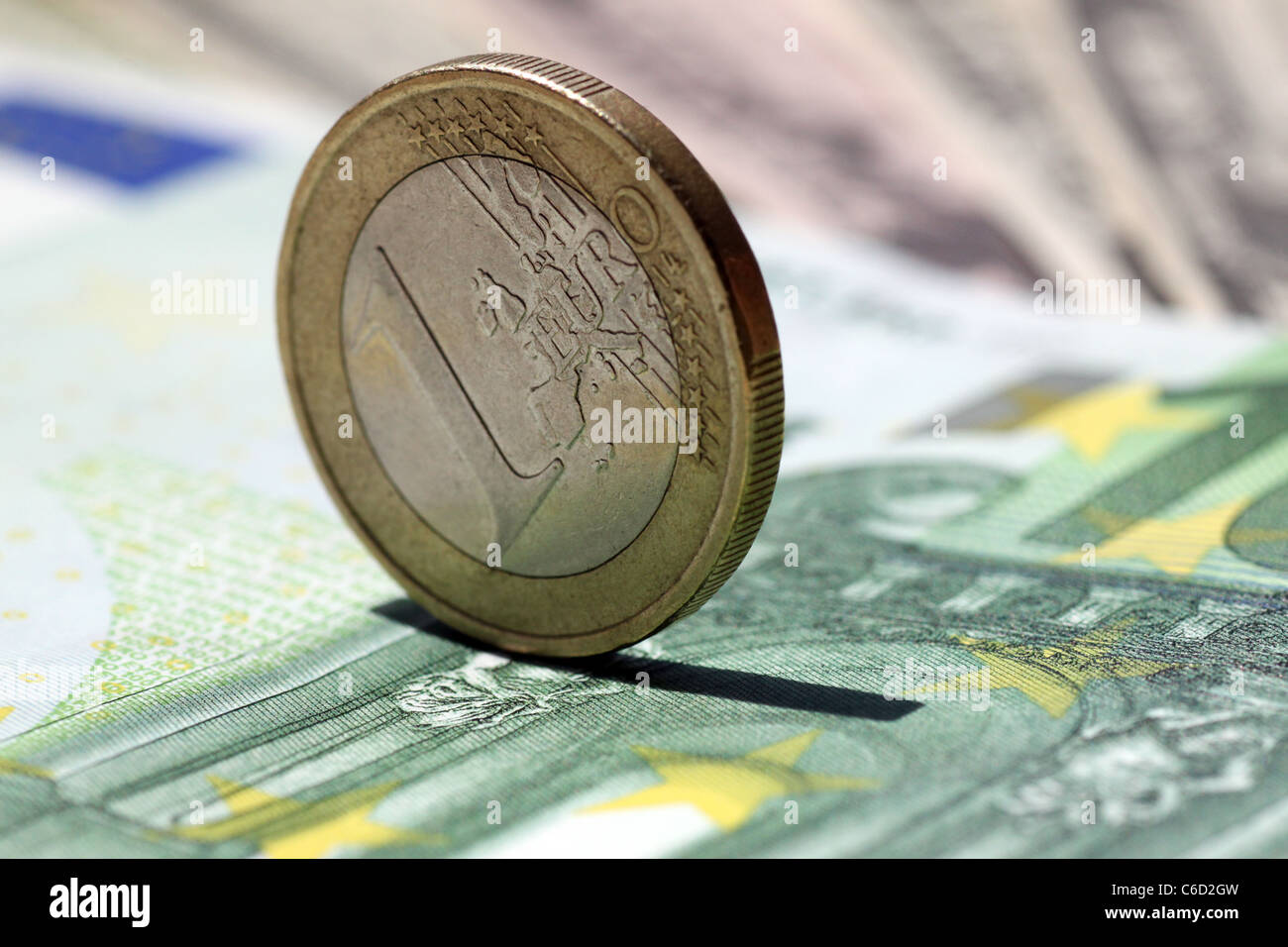 one euro coin on a one hundred euro banknote Stock Photo
