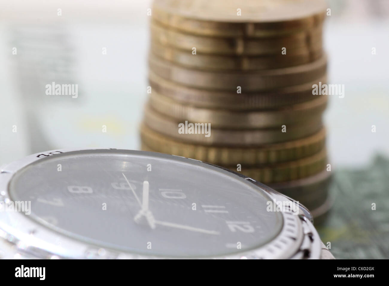 time is money watch in front of pile of euro coins Stock Photo Alamy