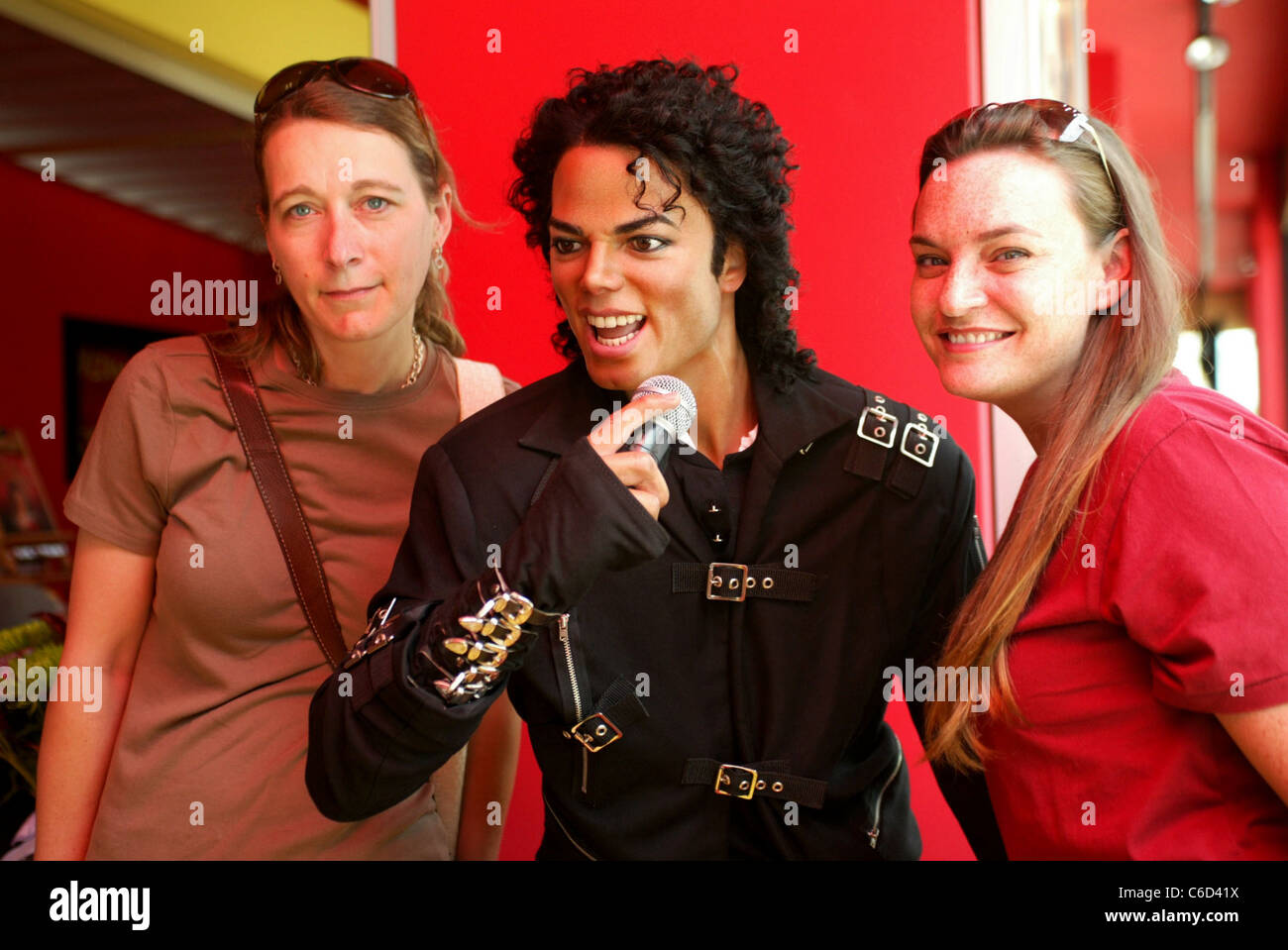 Fans posing with Michael Jackson's wax figure Madame Tussauds in