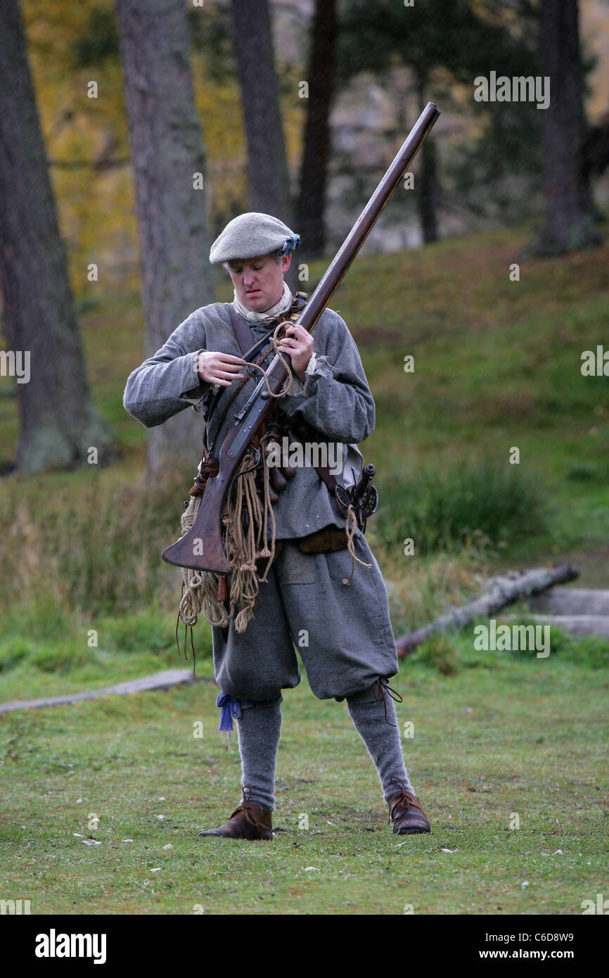 A member of [Fraser's Dragoons], a 17th century re-enactment society, loading his musket Stock Photo