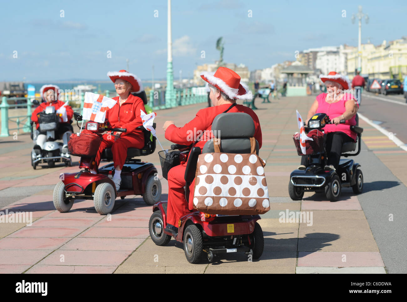 The famous Red Tarts formation mobilty scooter team performing to a crowd on Brighton seafront for the mayors charity walk Stock Photo