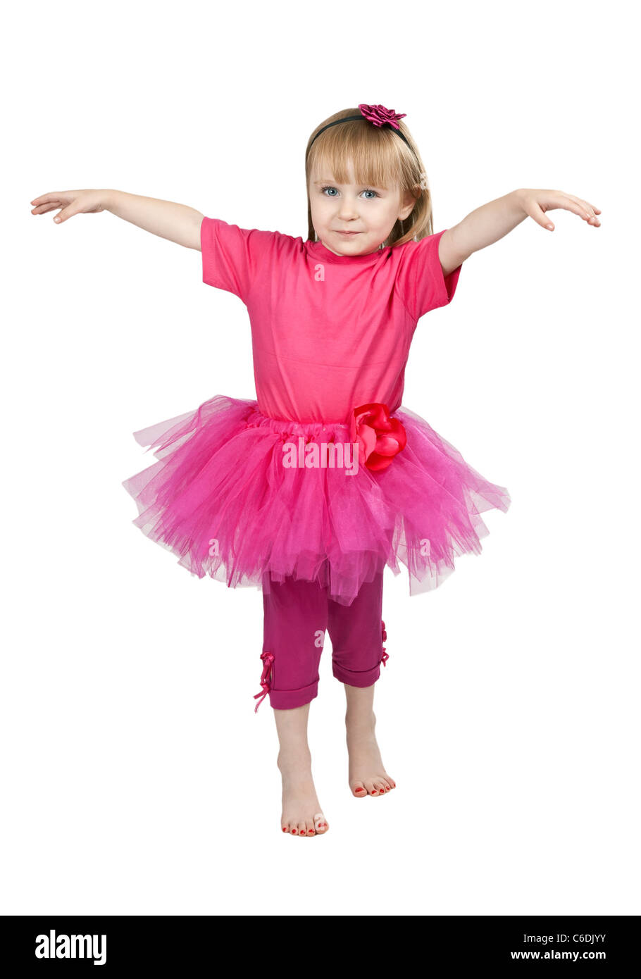 little girl in a pink dress dancing in studio isolated on a white