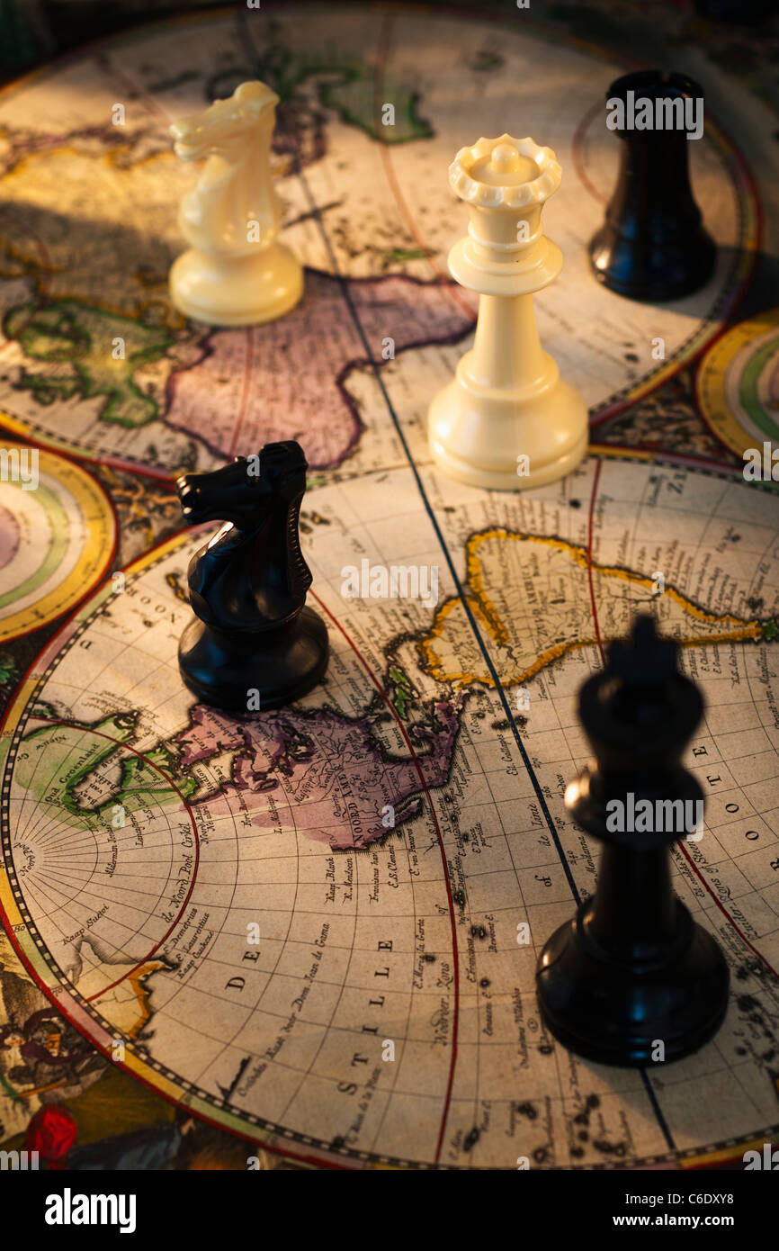 Chess pieces on old world map Stock Photo