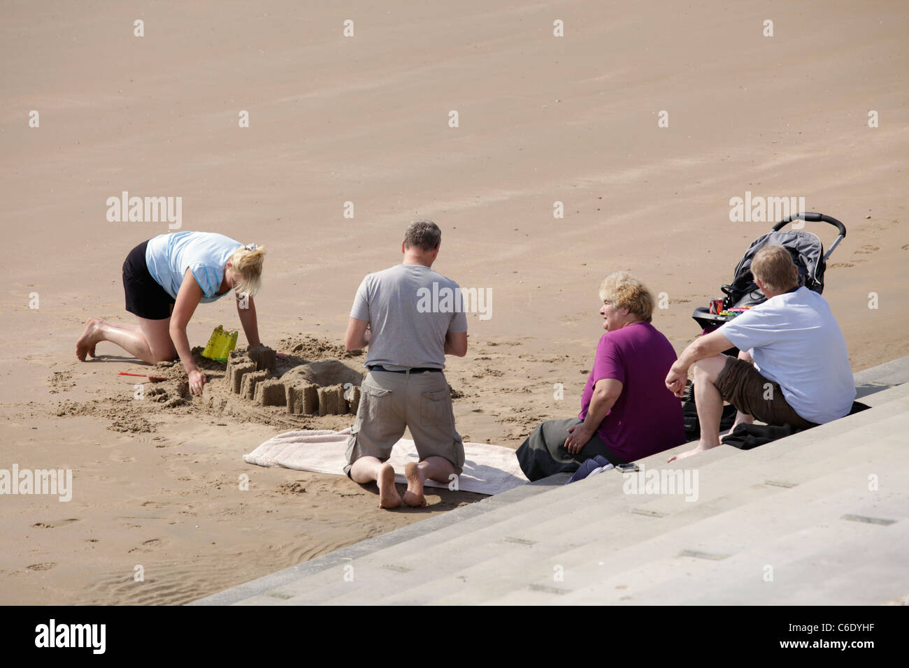 Adults making sand castles on Dymchurch beach Kent Stock Photo