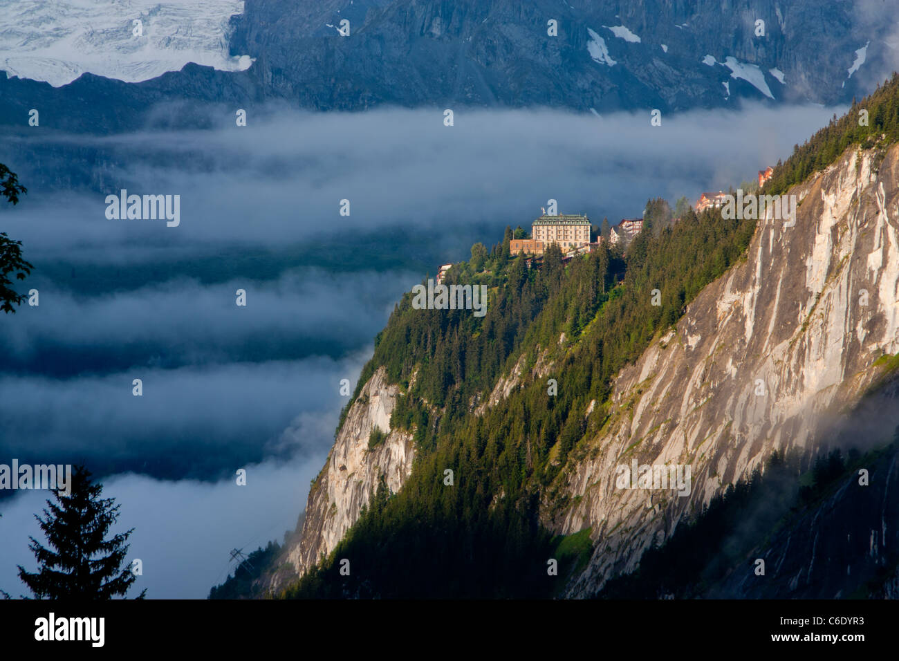 Murren village in morning mist above Lauterbrunnen valley with snowy ...