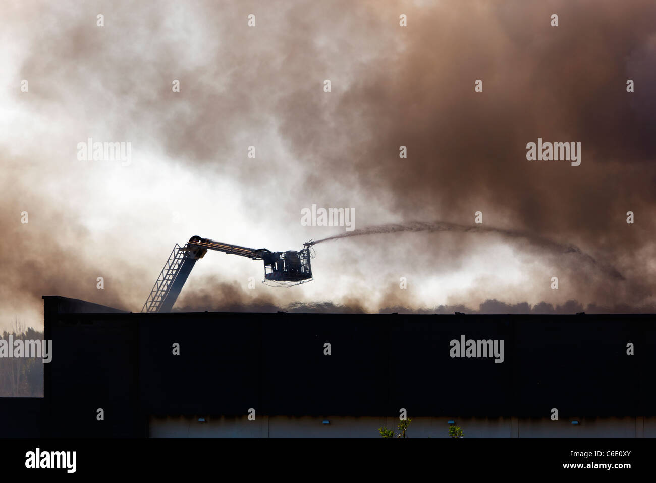 Fighting fire with remote controlled hose on ladder. Stock Photo