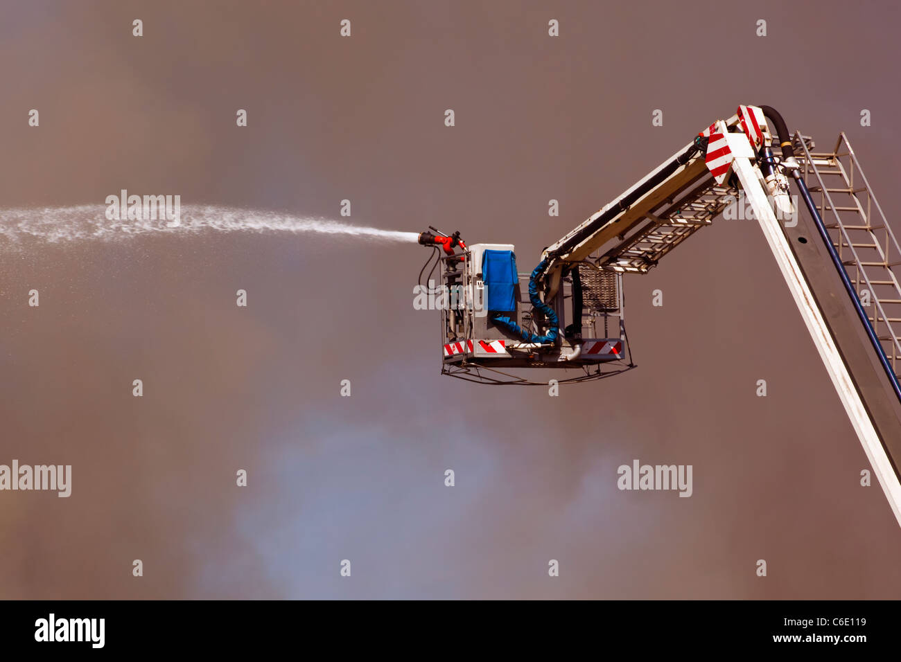 Fighting fire with remote controlled hose on ladder. Stock Photo
