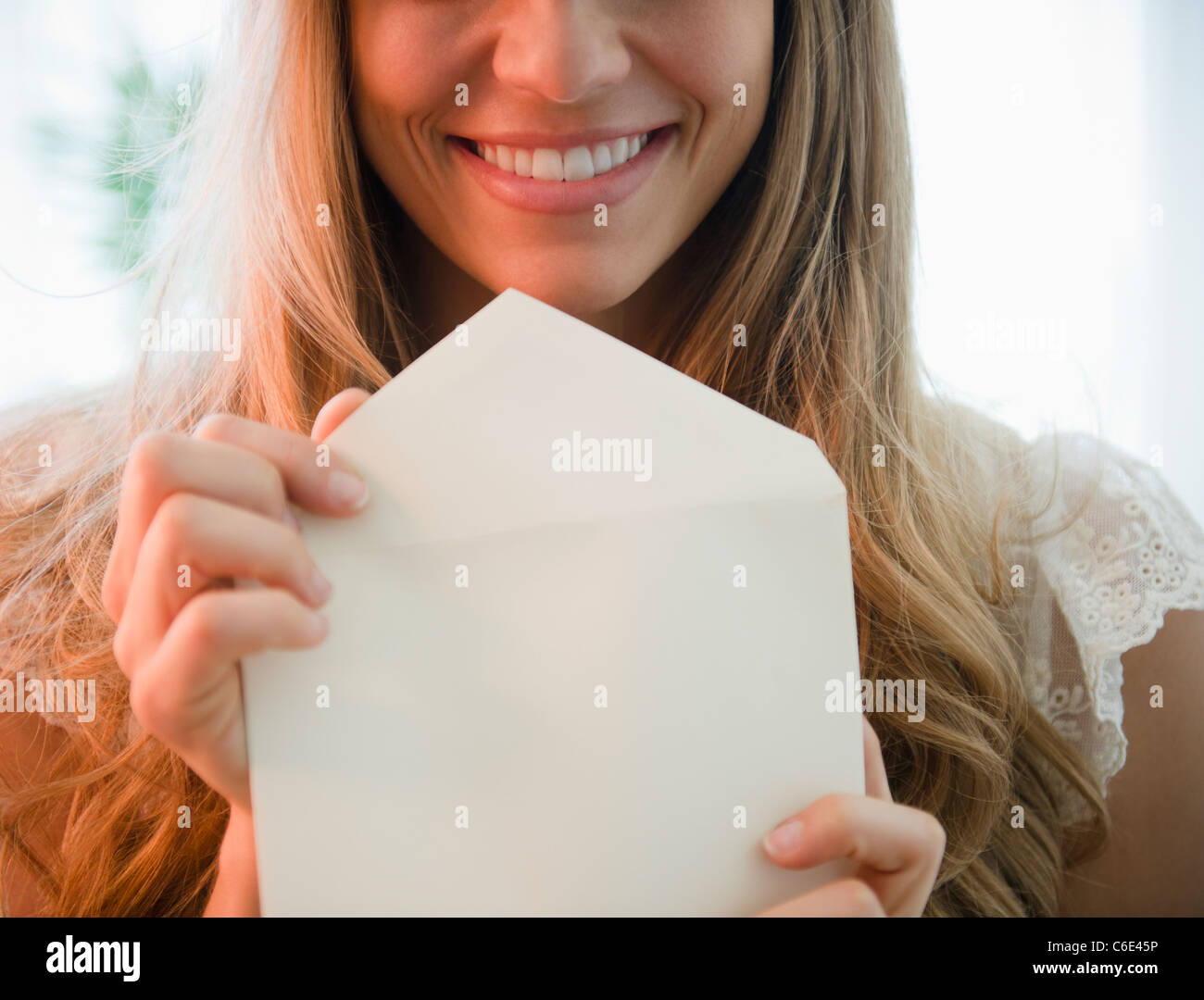 USA, New Jersey, Jersey City, Portrait of blonde woman holding envelope Stock Photo