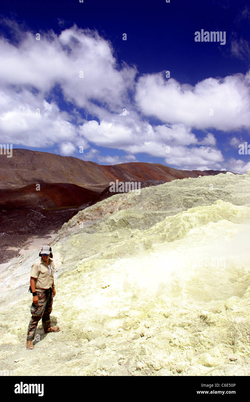 Man standing on sulfur Mine on the west side of the Sierra Negra Volcano. Isla Isabela, Galapagos, Ecuador, South America Stock Photo