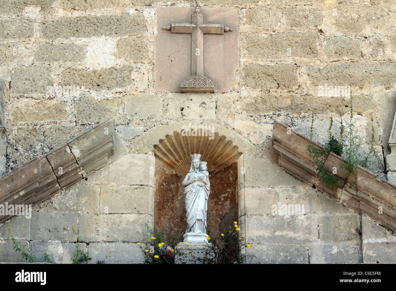 A sculpture of Mary and Jesus in an alcove on the wall of a Christian