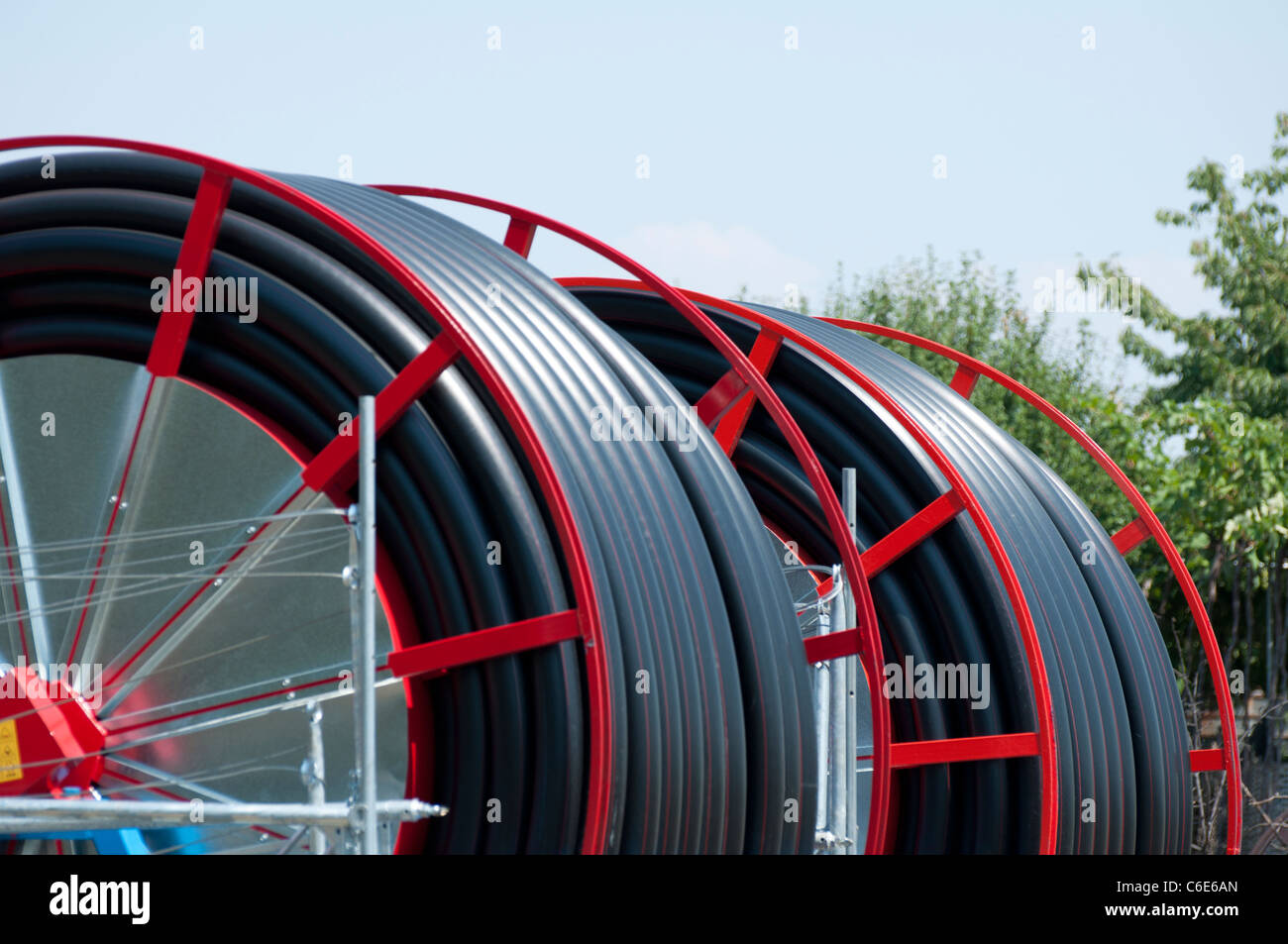 Black hoses for irrigation of agricultural land. Two rollers Stock Photo Alamy