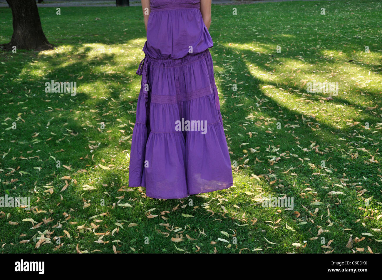 Young woman wearing purple dress standing in a park outdoors Stock ...