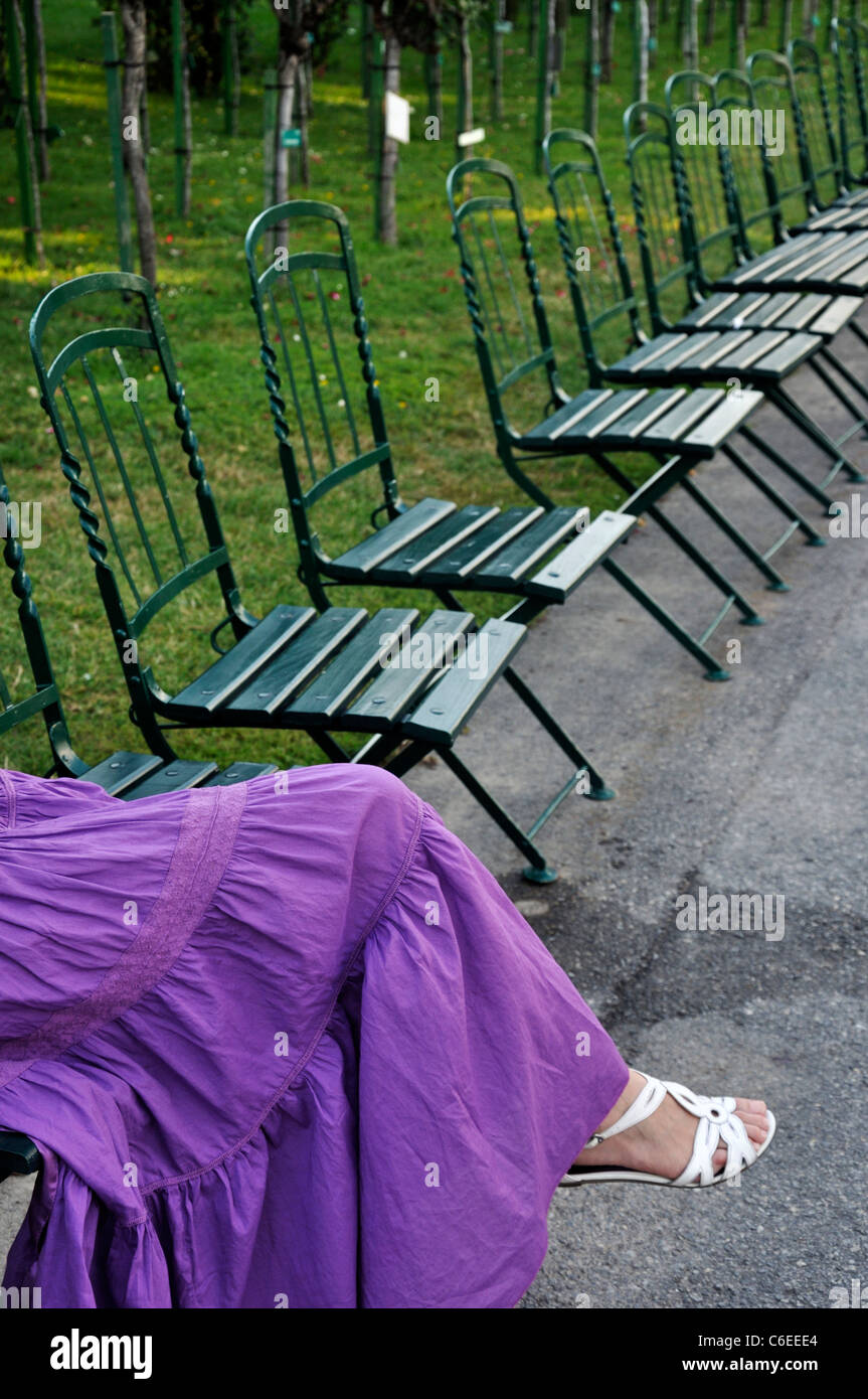 Young woman wearing purple dress sitting in a park outdoors Stock Photo ...